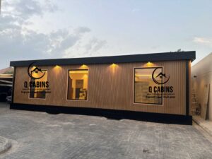 واجهة غرفة جاهزة ببديل الخشب مع إضاءة ليلية تعكس جمال التشطيب الخارجي.