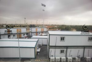 مجمع غرف ساندوتش بانل مكون من دورين مع درجات خارجية في موقع مخصص للاستراحات أو المكاتب.