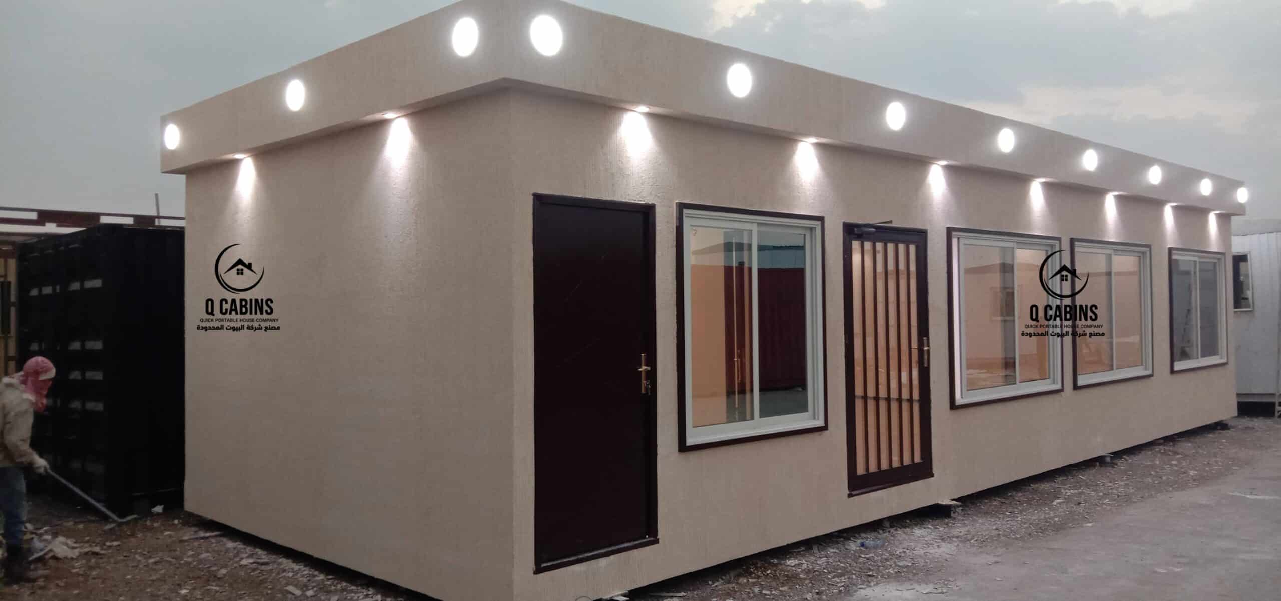 Illuminated cement board porta cabin office with exterior roof spotlights.