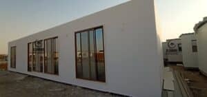 Modern white cement board porta cabin with large sliding glass windows for site offices.
