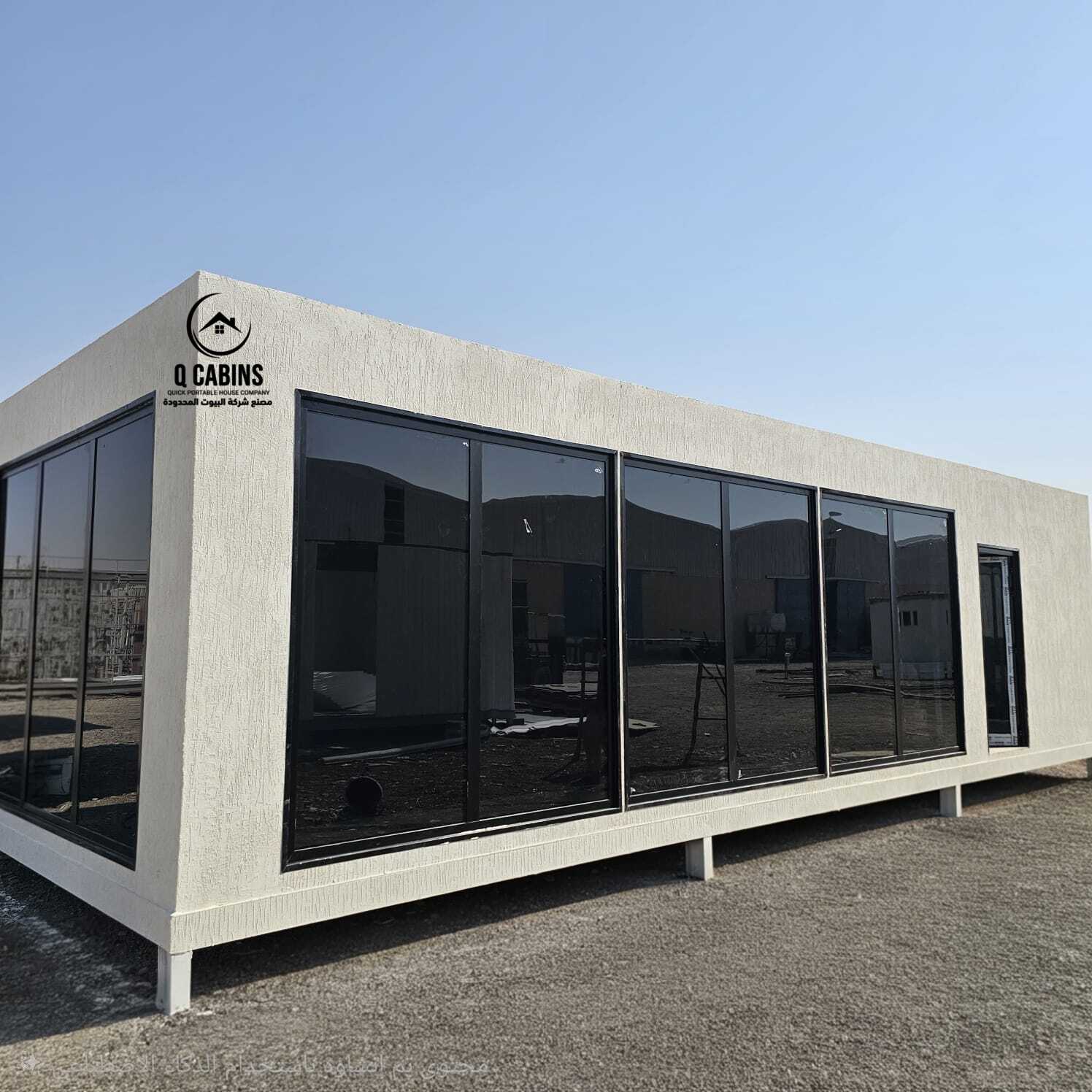 Side angle of white cement board modular porta cabin. with big black windows