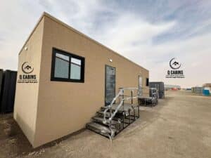 Side angle of a long beige prefabricated cement board site office cabin.