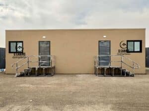Beige cement board porta cabin with dual entrance doors and steel access stairs.