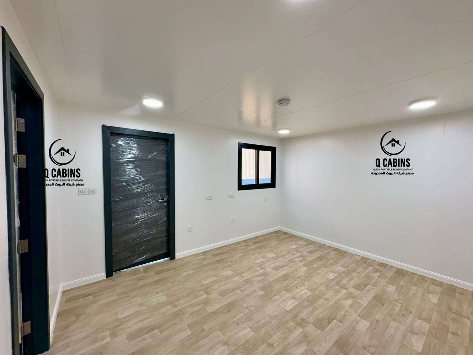 Interior view of a finished prefab cement board porta cabin with wood flooring and lighting