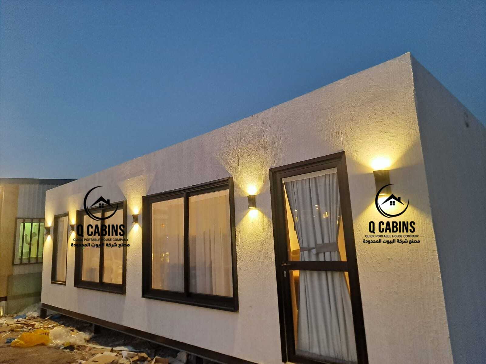 Exterior view of a modern prefab office porta cabin with outdoor lights