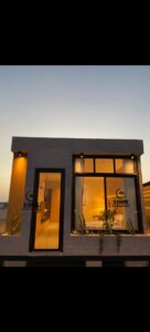 Vertical night view of a glowing luxury prefab porta cabin setup