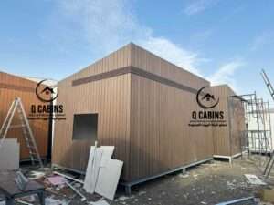 Angle view of a modern prefabricated porta cabin with grey cladding accents and wood cladding