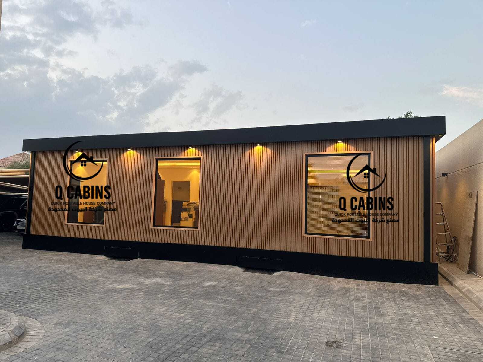 Modern prefabricated house with warm WPC wood plastic composite cladding and exterior lighting