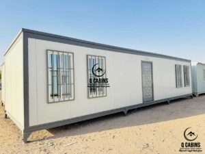 Exterior of long sandwich panel site cabin featuring security window grills