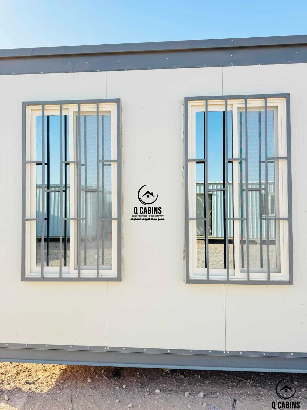 Close-up view of white sandwich panel wall with window security grilles
