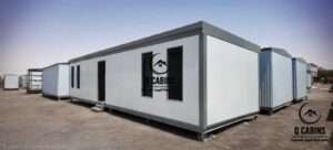 White insulated sandwich panel portable cabin with dark window frames and door