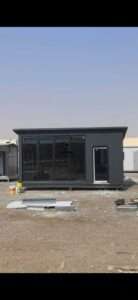 Modern dark grey sandwich panel site office with floor-to-ceiling glass panel facade