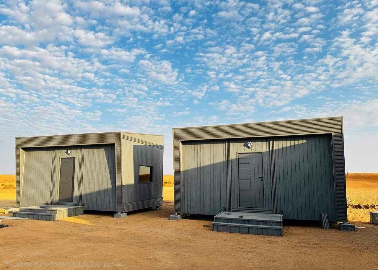غرف بركسات وكرفانات جاهزة متنقلة بتصميم خارجي مودرن بلون رمادي ومداخل مرتفعة تناسب الاستراحات والمخيمات   